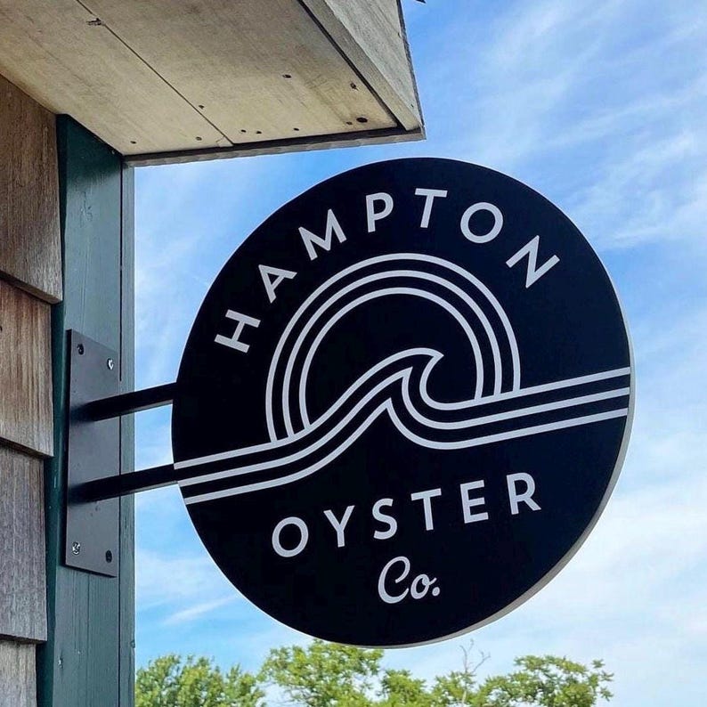 Black custom round blade sign for seafood restaurant storefront