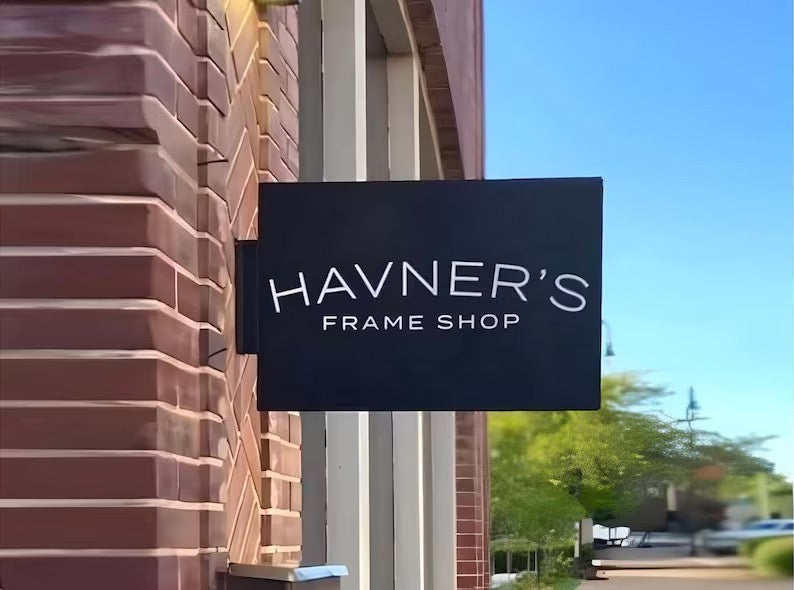 Black rectangular blade sign for a frame shop storefront