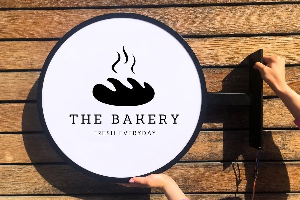 Illuminated round blade sign for a bakery storefront