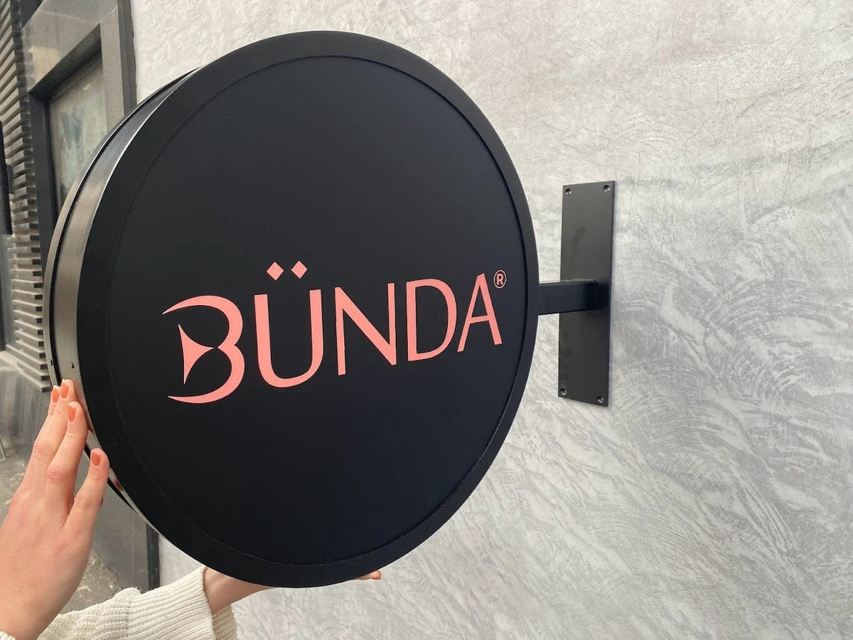 LED projecting blade sign with custom BÜNDA logo, close-up view