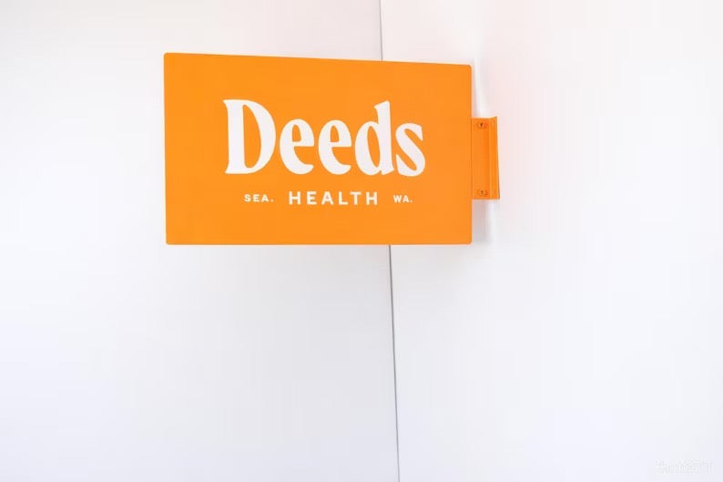 Orange custom rectangular blade sign mounted on a white wall