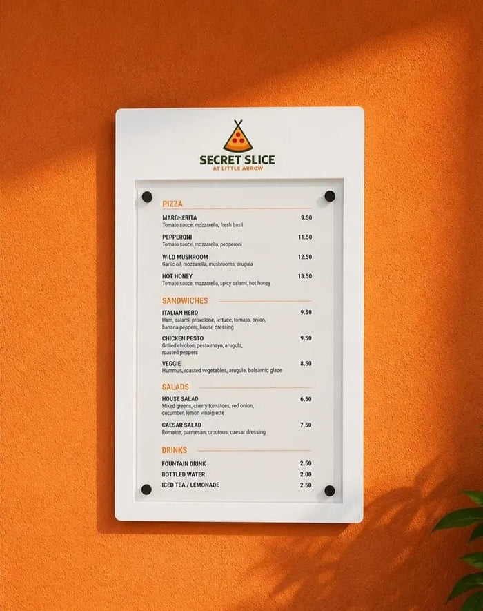 Wall-mounted menu display case with protective front cover on an orange restaurant wall